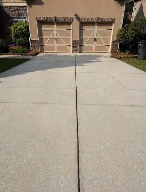 After cleaning by East Alabama Surface Clean. Wide driveway apron in front of a double garage, dirty then cleaned