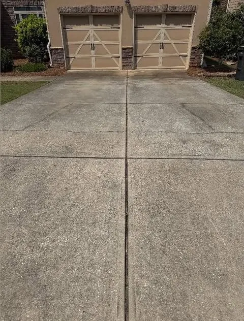 Before cleaning. Wide driveway apron in front of a double garage, dirty then cleaned