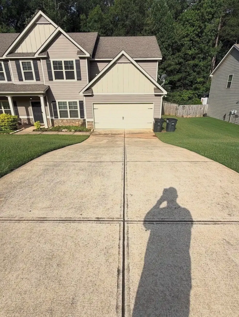 Before cleaning. Driveway in front of a two-story home, dirty then cleaned