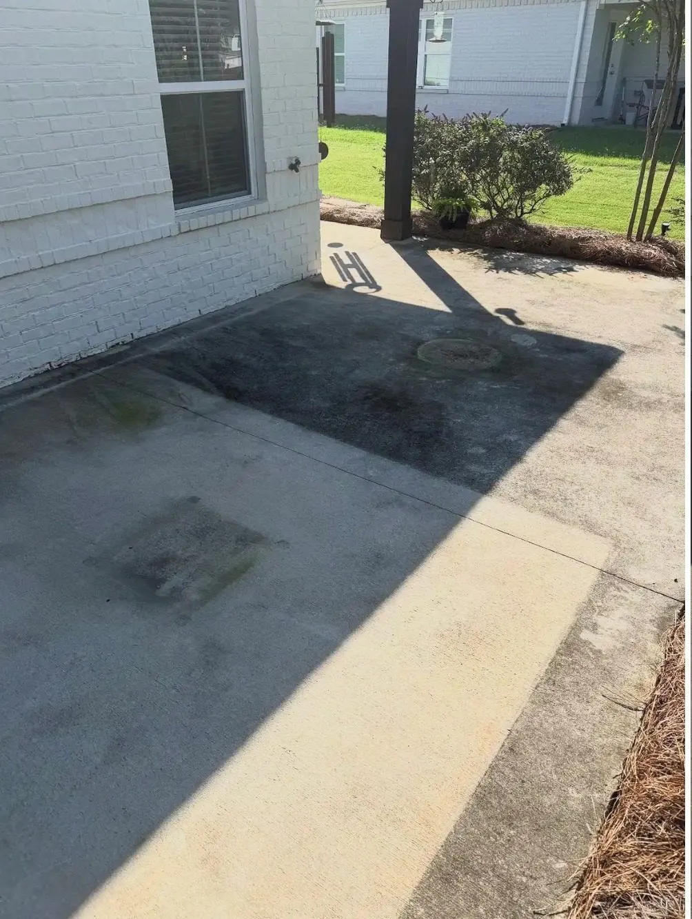 Before cleaning. Concrete patio with heavy dark algae growth, then cleaned
